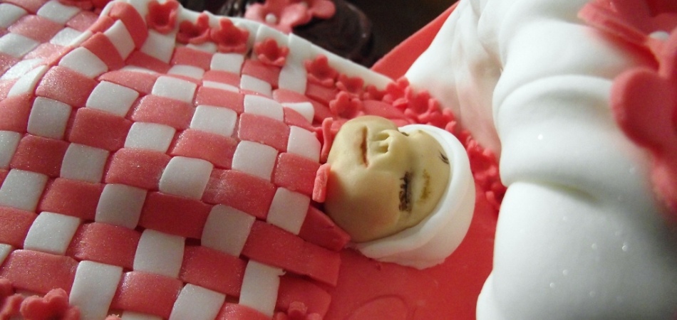 "Novelty baby shower cake with matching cupcakes"